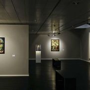 Ausstellungsansicht, erkennbar im Hintergrund sind ein Bild von Wilhelm Morgener, ein Bischofsstab und ein Bild der Kreuzigung. 