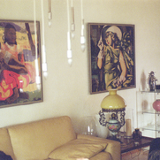 Fotografie von mehreren Gemälden über einer Couch.