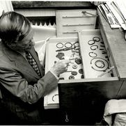 Wilhelm Hack sitzend vor einigen kleineren Stücken des Gondorfer Fundes in einer Schublade. Das Bild entstand 1974 in seinem Haus.
